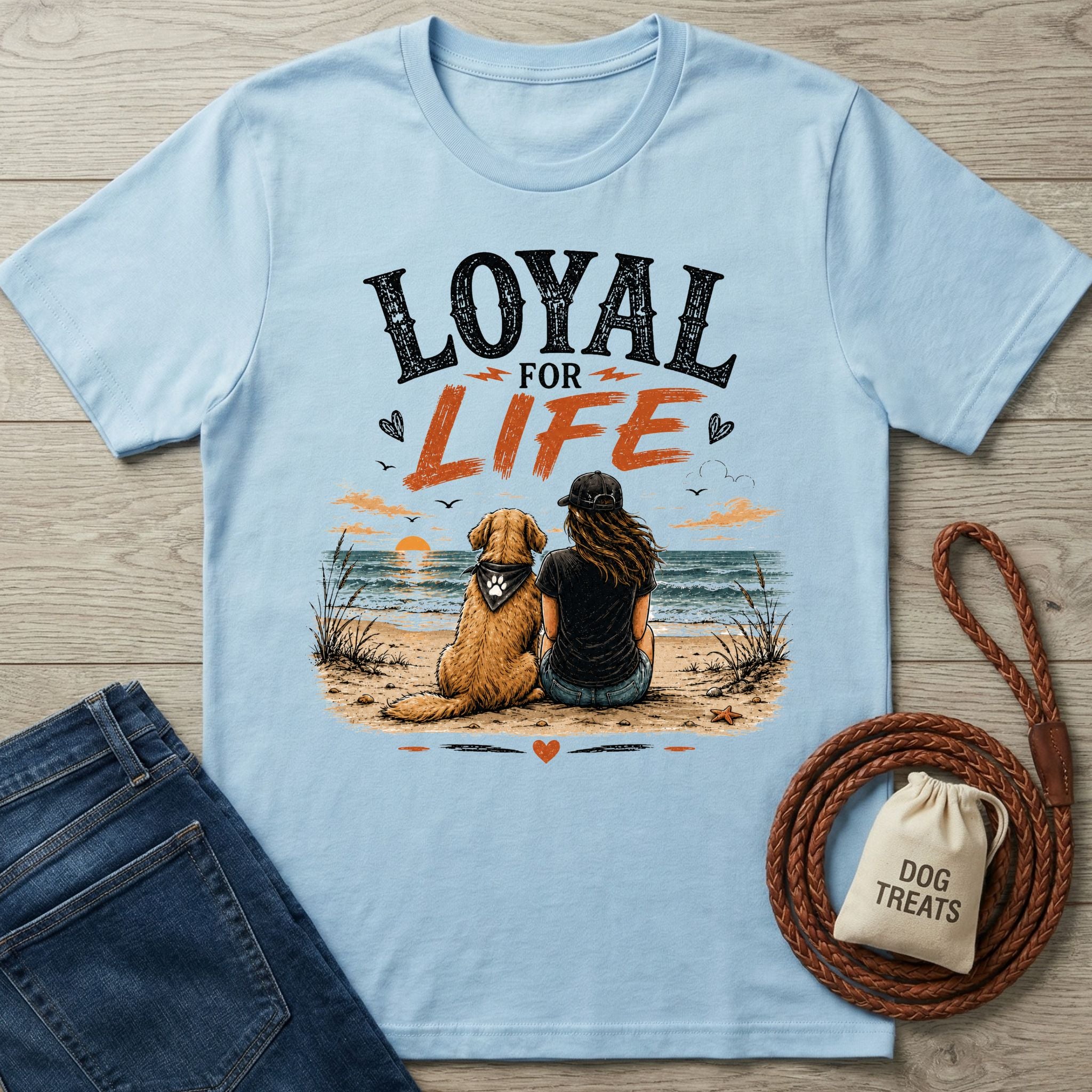 Light blue crewneck t-shirt featuring a graphic of a woman and dog sitting on a beach with the text Loyal For Life.