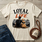 Cream-colored cotton t-shirt featuring a graphic of a man and his dog overlooking mountains with the text Loyal For Life.