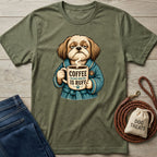 Olive green crewneck t-shirt featuring a grumpy dog in a blue robe holding a coffee mug that says Coffee Because Adulting Is Ruff.