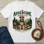 White crewneck t-shirt featuring a graphic of a dog holding a leash on a mountain trail with Adventure Awaits text.