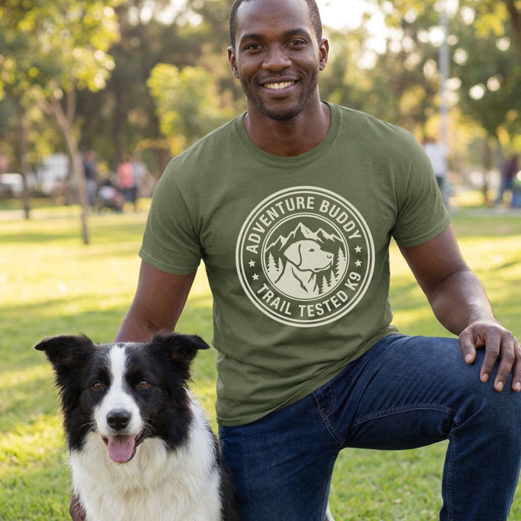 Man in an olive green "Adventure Buddy Trail Tested K9" t-shirt with a black and white border collie.