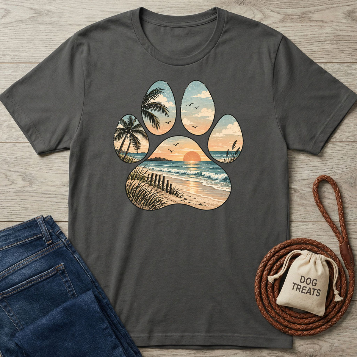 Charcoal gray t-shirt featuring a paw print graphic with a sunset beach, palm trees, and ocean waves design.