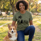 Woman wearing an olive green crewneck t-shirt featuring a black graphic of a dog sitting on a beach at sunset.