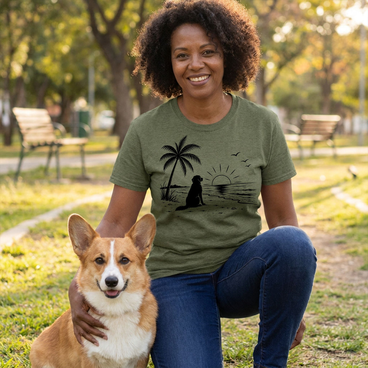 Woman wearing an olive green crewneck t-shirt featuring a black graphic of a dog sitting on a beach at sunset.