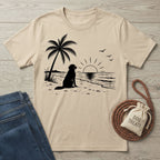 Beige crewneck t-shirt featuring a black graphic of a dog sitting on a beach under a palm tree at sunset.