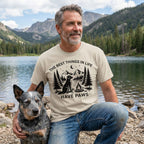 Beige crewneck t-shirt featuring a black graphic of a dog, campfire, and mountains with the text The Best Things In Life Have Paws.