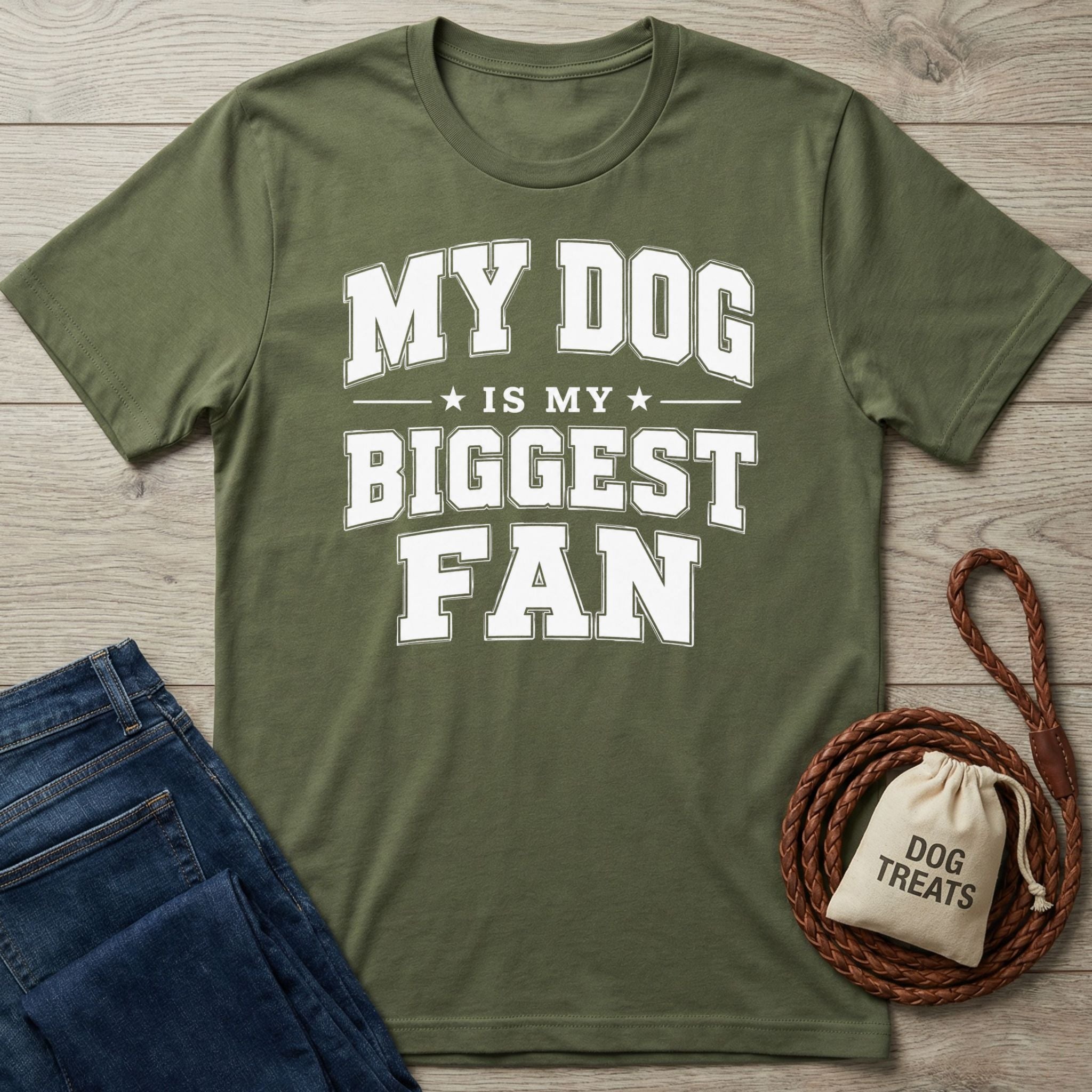 Olive green crewneck t-shirt with white My Dog Is My Biggest Fan text, displayed with blue jeans and a dog treat bag.