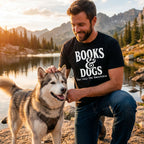 Man wearing a black graphic T-shirt that reads "Books & Dogs" while petting a husky by a mountain lake.