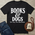 Black crewneck T-shirt with white Books & Dogs graphic text, laid flat next to blue jeans, a leather leash, and a treat bag.