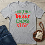 Grey crewneck T-shirt with red and green Christmas text reading Christmas is better with a dog by your side.