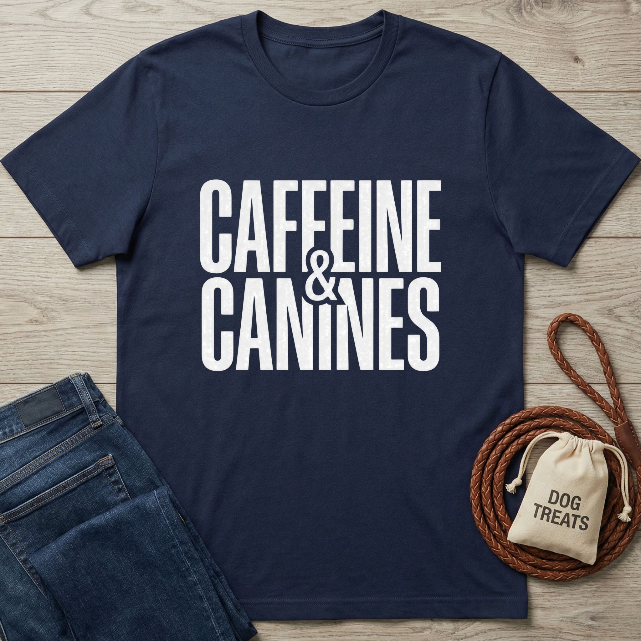 Navy blue Gildan Softstyle® t-shirt with "Caffeine & Canines" in white text, next to jeans and dog treats.