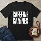 Black Gildan Softstyle t-shirt with "Caffeine & Canines" text, next to jeans, a leash, and dog treats.