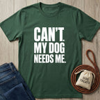 Forest green crew neck t-shirt with white text reading Can't. My Dog Needs Me, styled with a leather leash and treat bag.