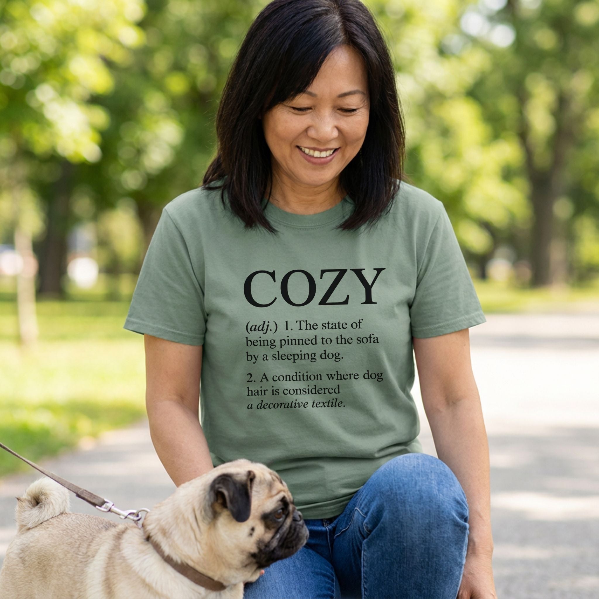 Woman in an olive green "Cozy Definition" Gildan Softstyle® t-shirt with a pug.