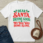 White crewneck T-shirt with festive red and green Dear Santa Define Good text, holly accents, and a paw print graphic.