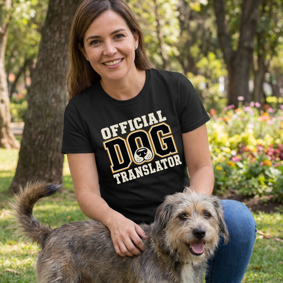 Woman wearing a black crew neck t-shirt with Official Dog Translator text and a dog nose graphic, posing with a dog outdoors.