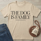 Beige Gildan Softstyle® t-shirt with "THE DOG IS FAMILY" text, next to jeans and dog treats.