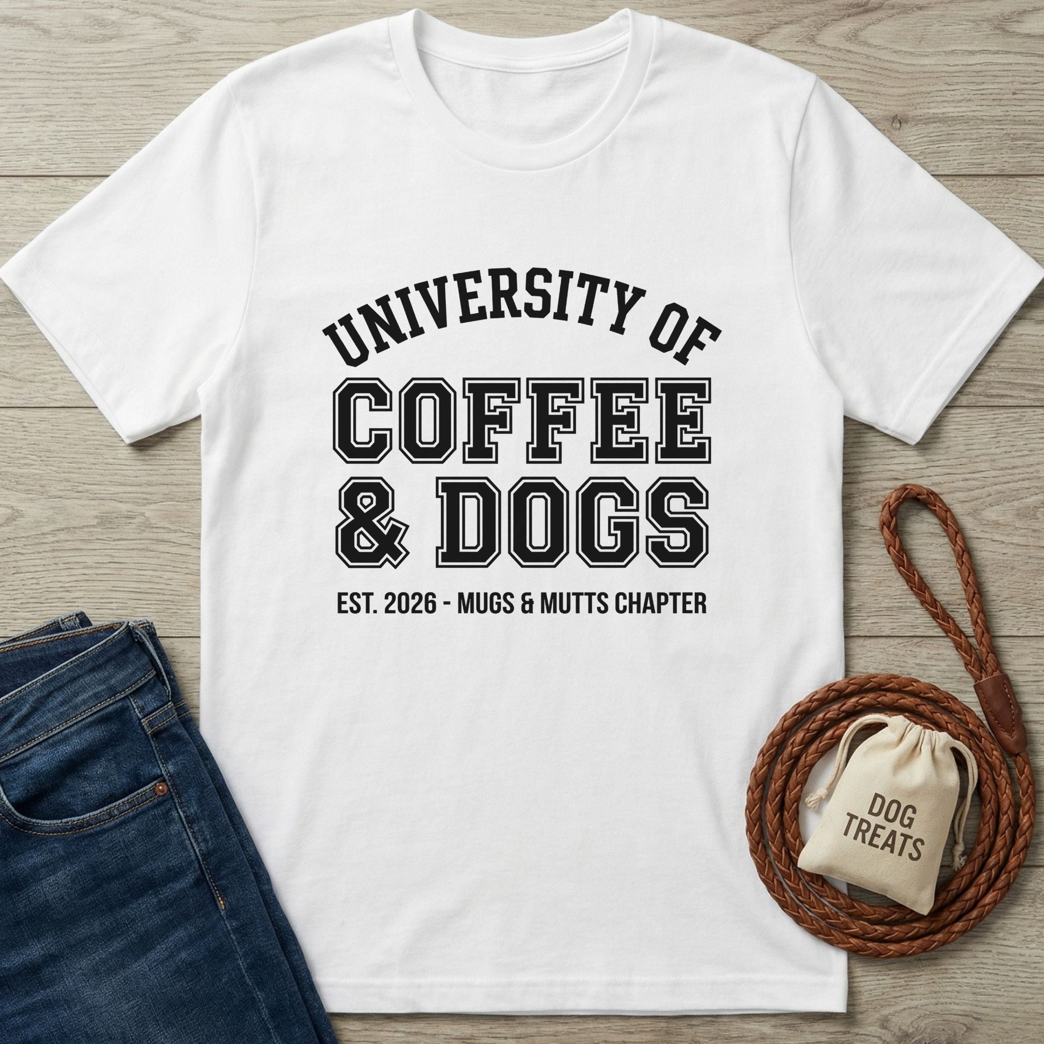 White Gildan Softstyle® t-shirt with "University of Coffee & Dogs" graphic, next to jeans and dog treats.