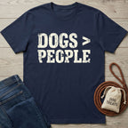 Navy blue Gildan Softstyle® 64000 t-shirt with "DOGS > PEOPLE" in distressed white text, next to jeans and dog treats.
