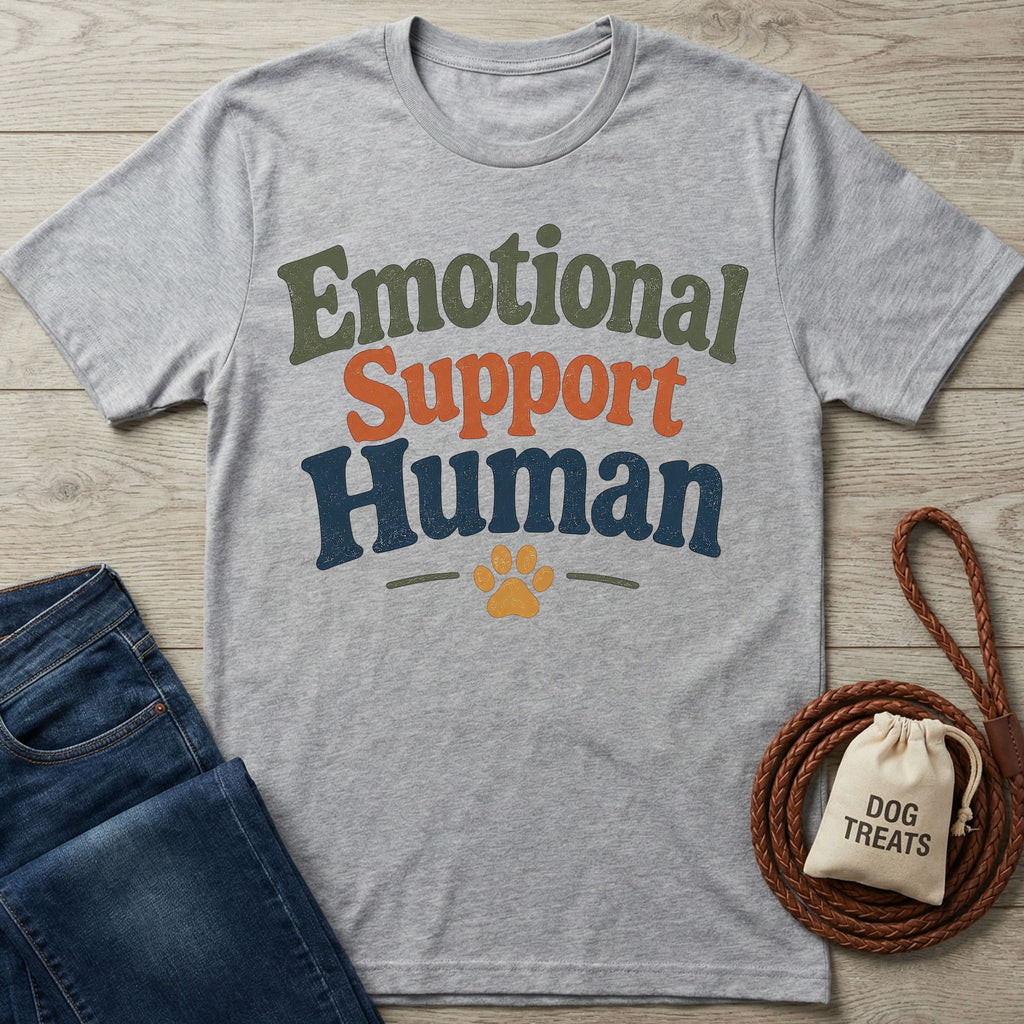 Heather gray "Emotional Support Human" t-shirt with a paw print, next to jeans and dog treats.