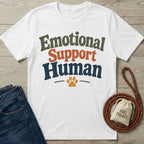 White cotton t-shirt with "Emotional Support Human" text, a paw print, jeans, and a dog leash with treats.