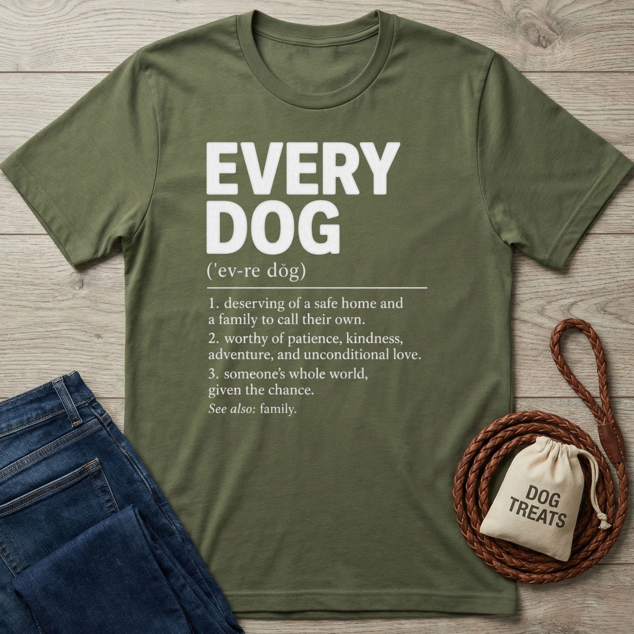 Olive green cotton t-shirt with white Every Dog dictionary definition print, displayed with blue jeans and a dog treat bag.