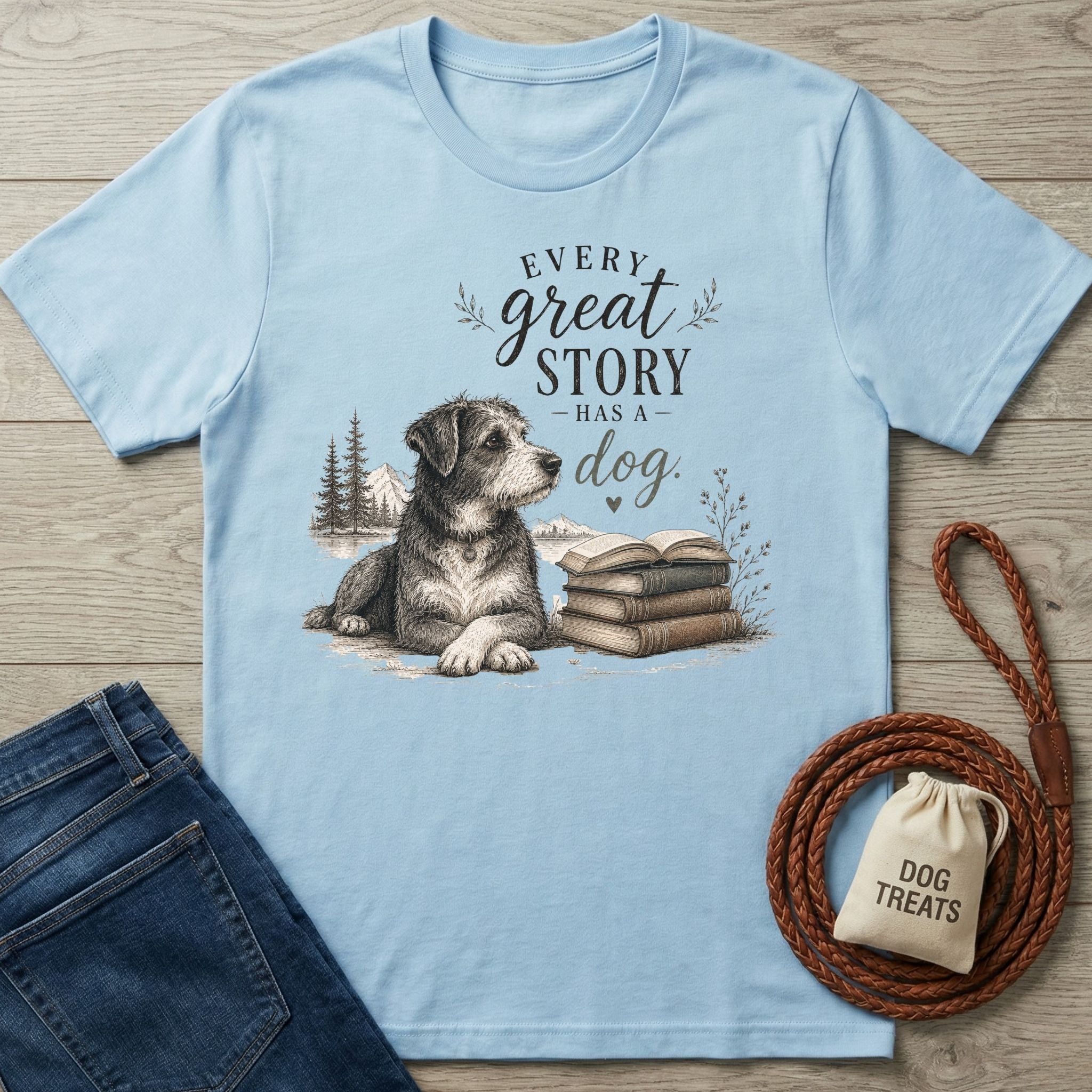 Light blue crewneck t-shirt featuring a sketch of a dog resting beside a stack of books and the text Every Great Story Has A Dog.