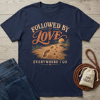 Navy blue crewneck T-shirt featuring a vintage beach graphic with human footprints and paw prints in the sand.