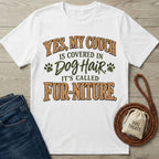 White graphic T-shirt with brown and green text reading Yes, My Couch Is Covered In Dog Hair, It's Called Fur-niture.