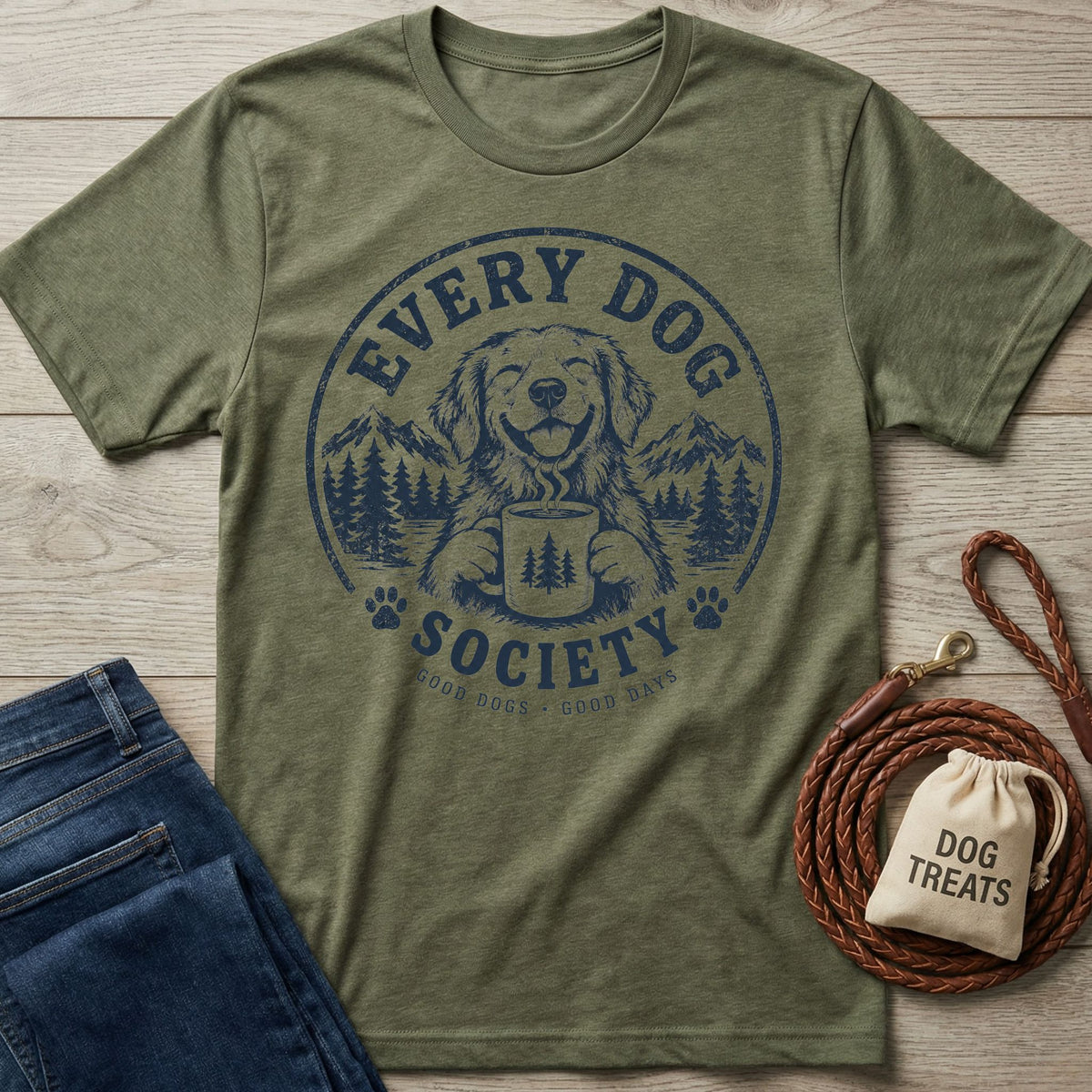 Olive green crewneck t-shirt featuring a navy blue graphic of a dog holding a coffee mug in a mountain forest setting.
