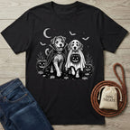 Black t-shirt featuring a white graphic of two dogs in Halloween costumes, a crescent moon, bats, and jack-o'-lanterns.
