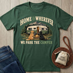 Forest green crewneck t-shirt featuring a vintage camper, campfire, and two dogs with the text Home Is Wherever We Park.