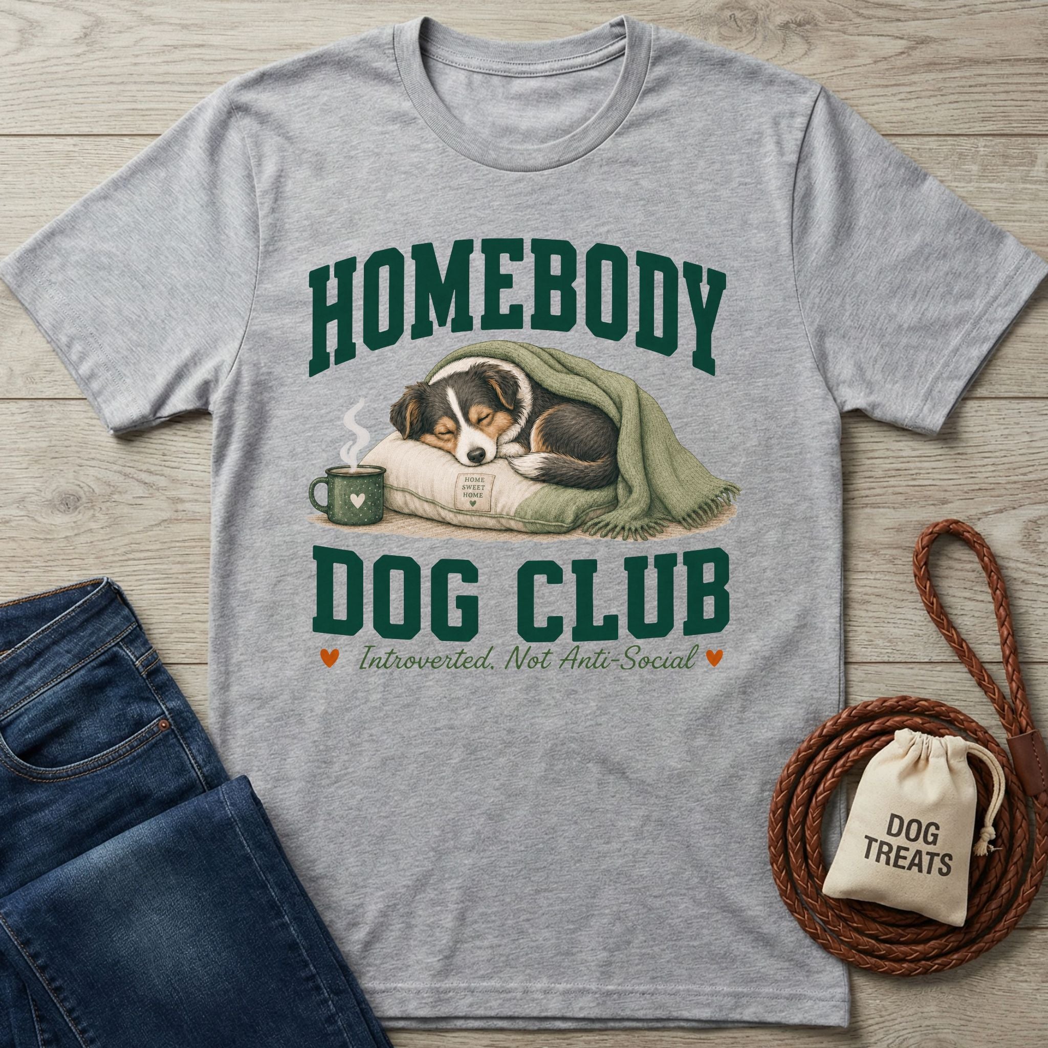 Grey crewneck t-shirt featuring a sleeping dog illustration, coffee mug, and Homebody Dog Club collegiate-style text.