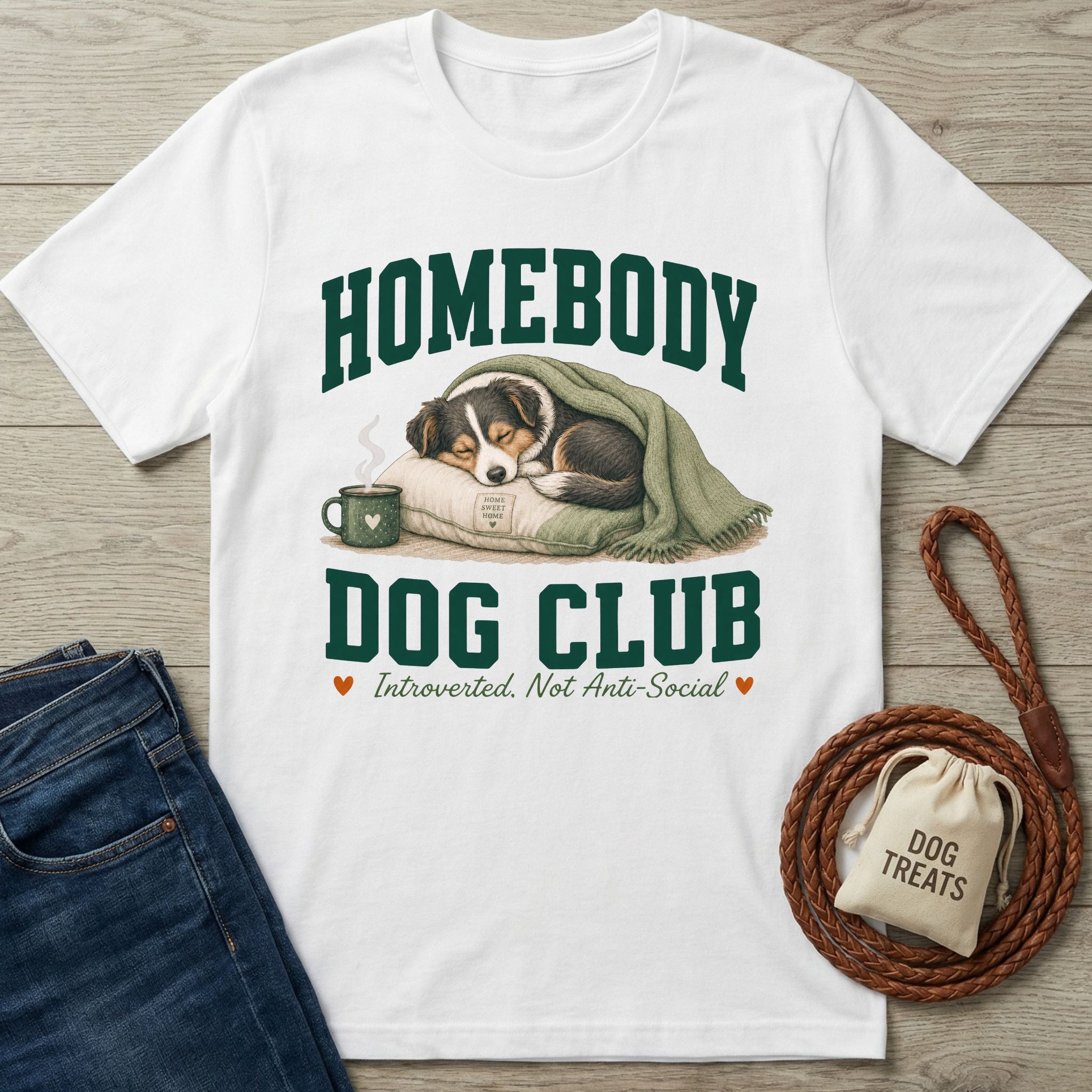 White crewneck t-shirt featuring a sleeping dog graphic, green collegiate text, and the slogan Homebody Dog Club.