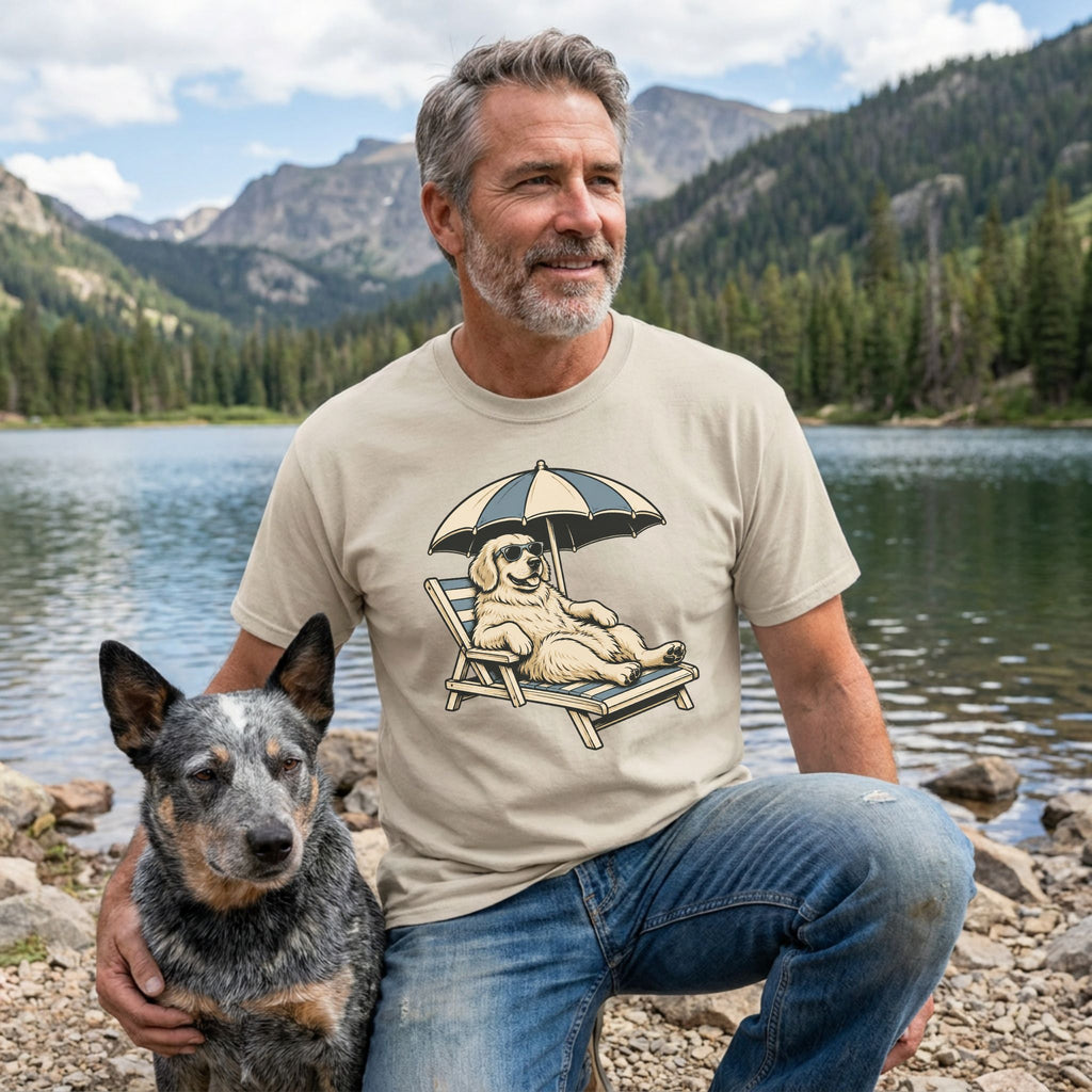 Man wearing a beige crewneck t-shirt featuring a graphic of a Golden Retriever lounging in a beach chair under an umbrella.