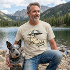 Man wearing a beige crewneck t-shirt featuring a graphic of a Golden Retriever lounging in a beach chair under an umbrella.