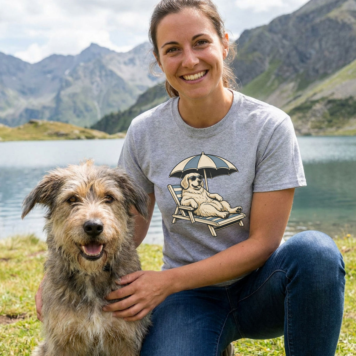 Woman wearing a grey Just Lounging t-shirt with a graphic of a dog in sunglasses relaxing on a beach chair under an umbrella.