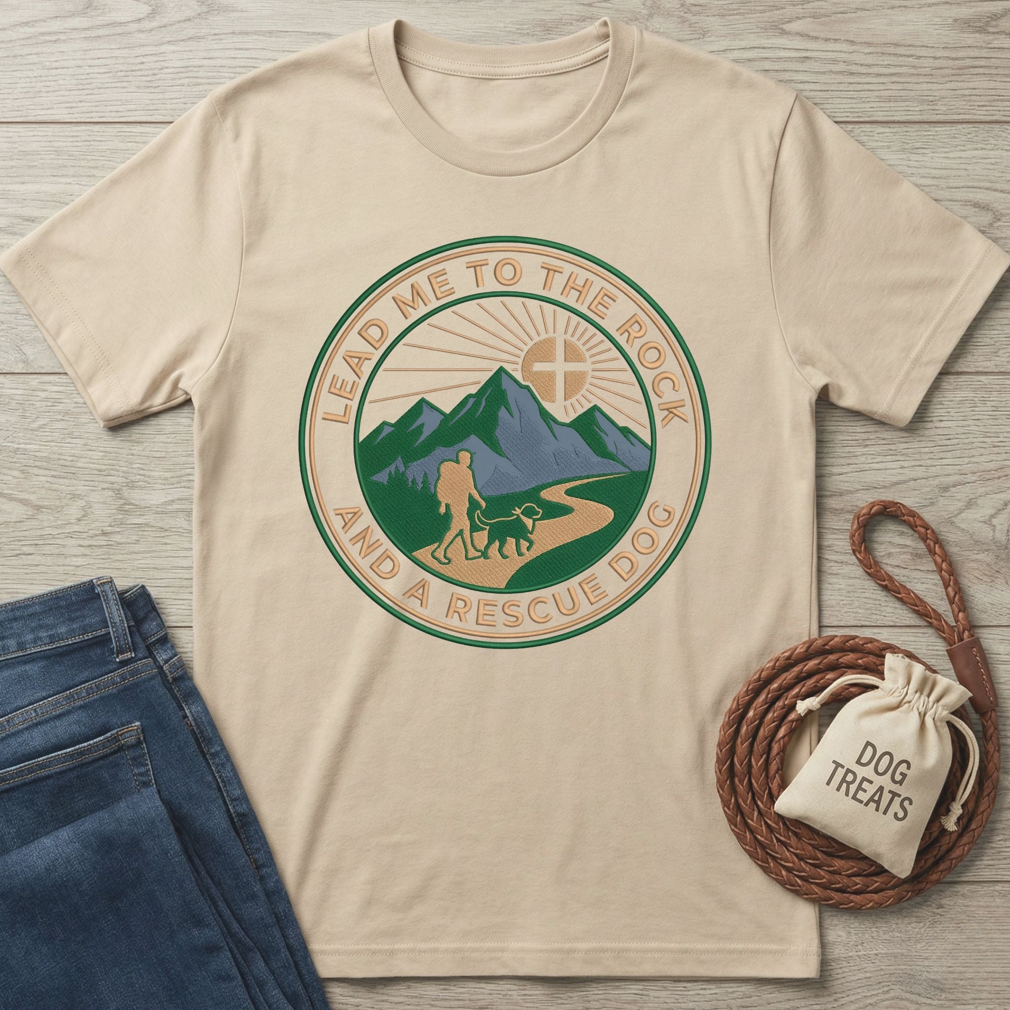 Beige Gildan Softstyle t-shirt with "Lead Me To The Rock And A Rescue Dog" graphic, jeans, and dog treats.