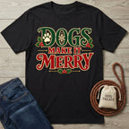 Black crewneck T-shirt with vintage-style Christmas lettering, holly, and paw print graphics, displayed on a wooden surface.
