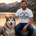 Man wearing a white crew neck t-shirt with Man's Best Friend graphic, sitting on a log by a lake with his dog.
