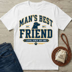 White crew neck t-shirt featuring a navy and gold Man's Best Friend dog graphic with a paw print on a wooden background.