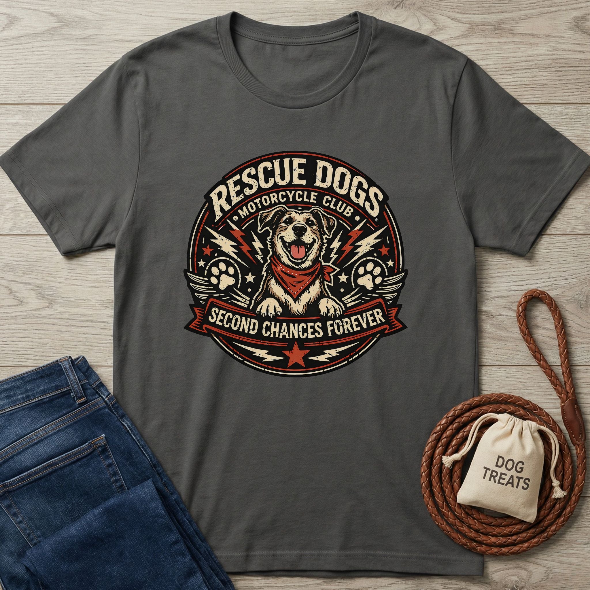 Charcoal gray Rescue Dogs Motorcycle Club t-shirt with a happy dog graphic, next to jeans and dog treats.