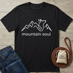 Black Gildan Softstyle® t-shirt with white "mountain soul" text and a mountain-dog line art design.