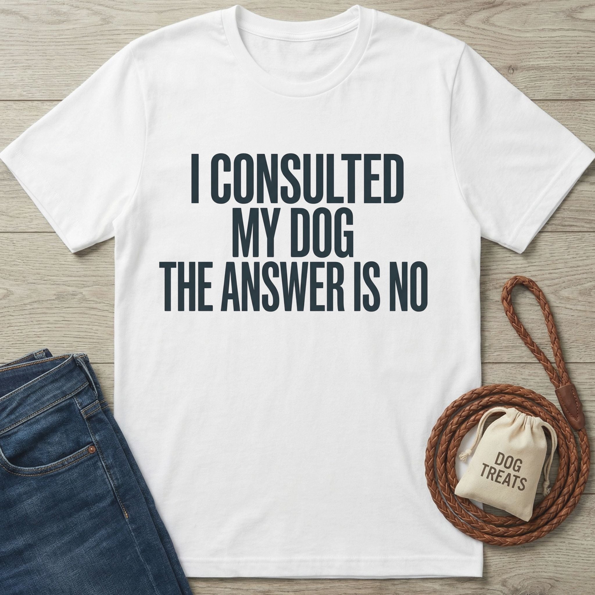 White Gildan Softstyle® 64000 t-shirt with "I CONSULTED MY DOG THE ANSWER IS NO" text, next to jeans and a dog leash.
