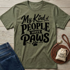 Olive green crewneck t-shirt with black My Kind of People Have Paws text and paw print graphic on a wooden background.