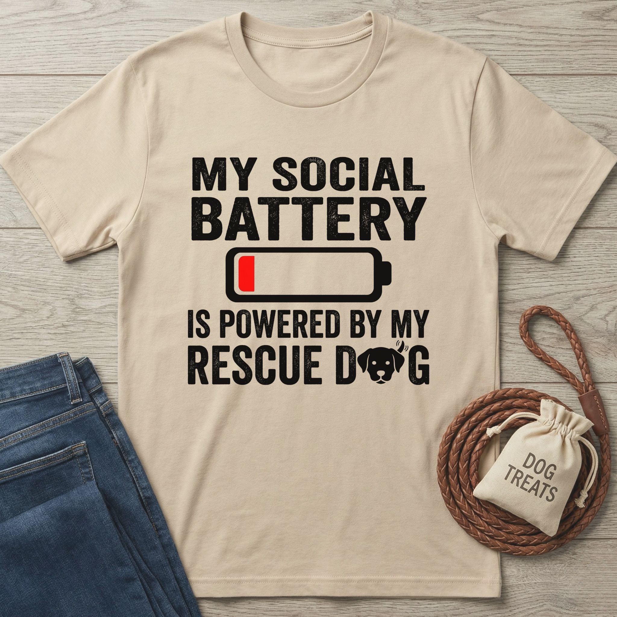 Beige Gildan Softstyle t-shirt with "My Social Battery Is Powered By My Rescue Dog" text and a low battery icon.