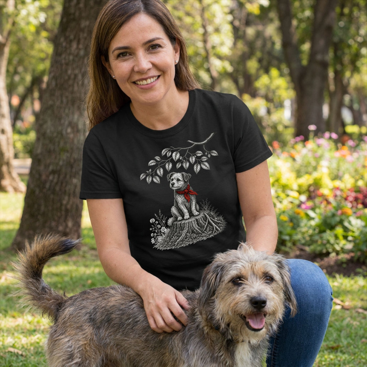 Woman wearing a black crewneck t-shirt featuring a white sketch of a puppy in a red bandana sitting on a tree stump.