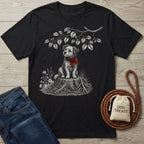 Black cotton t-shirt featuring a scruffy dog in a red bandana sitting on a tree stump illustration.