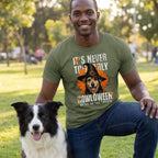 Man wearing an olive green t-shirt with a graphic of a dog in a witch hat and the text It's Never Too Early For Howloween.