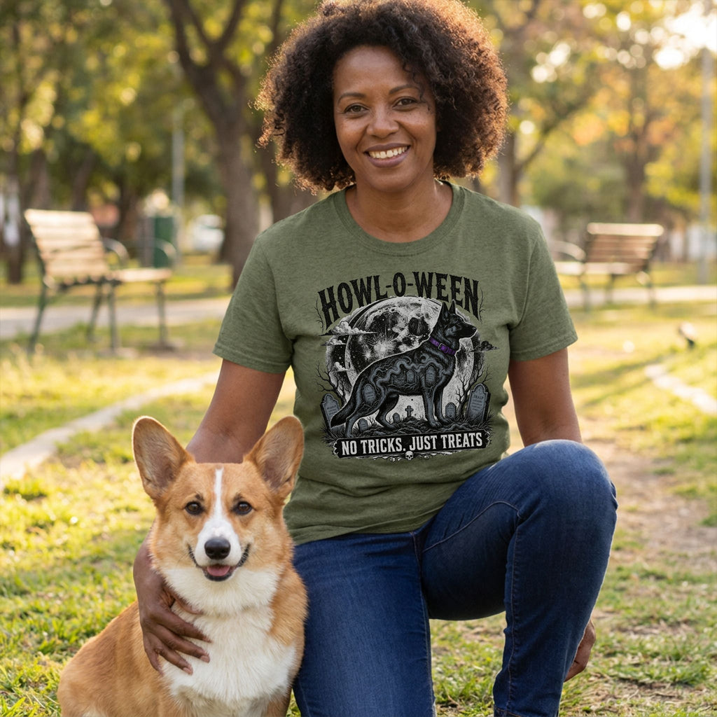 Woman wearing an olive green crewneck T-shirt featuring a Howl-o-ween dog graphic, posing outdoors with a corgi.
